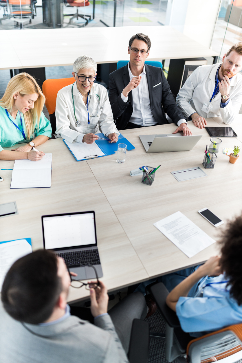 Above view of businessmen having a meeting with team of doctors in the office.